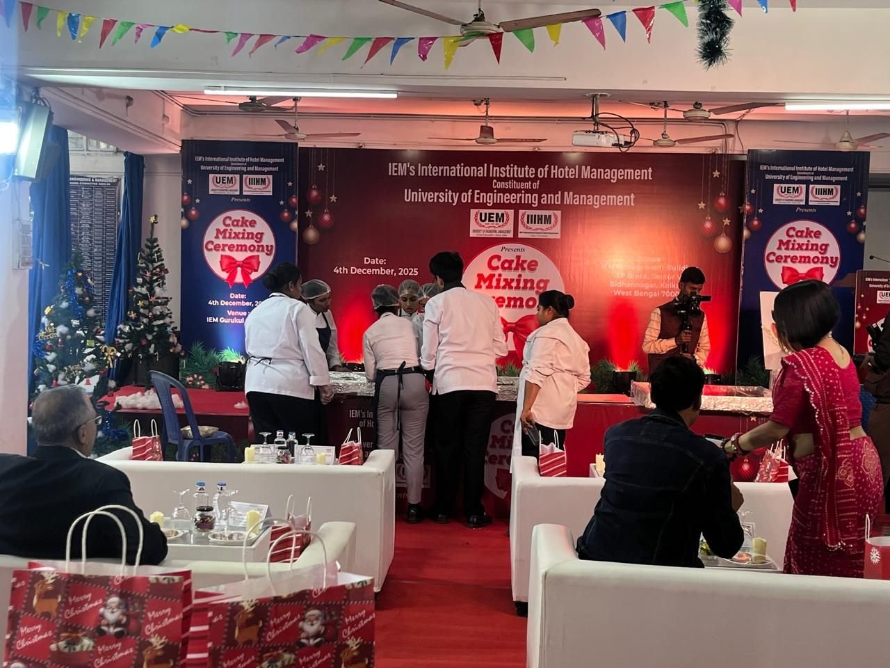 Institutional ceremony in progress on a decorated stage with seated guests