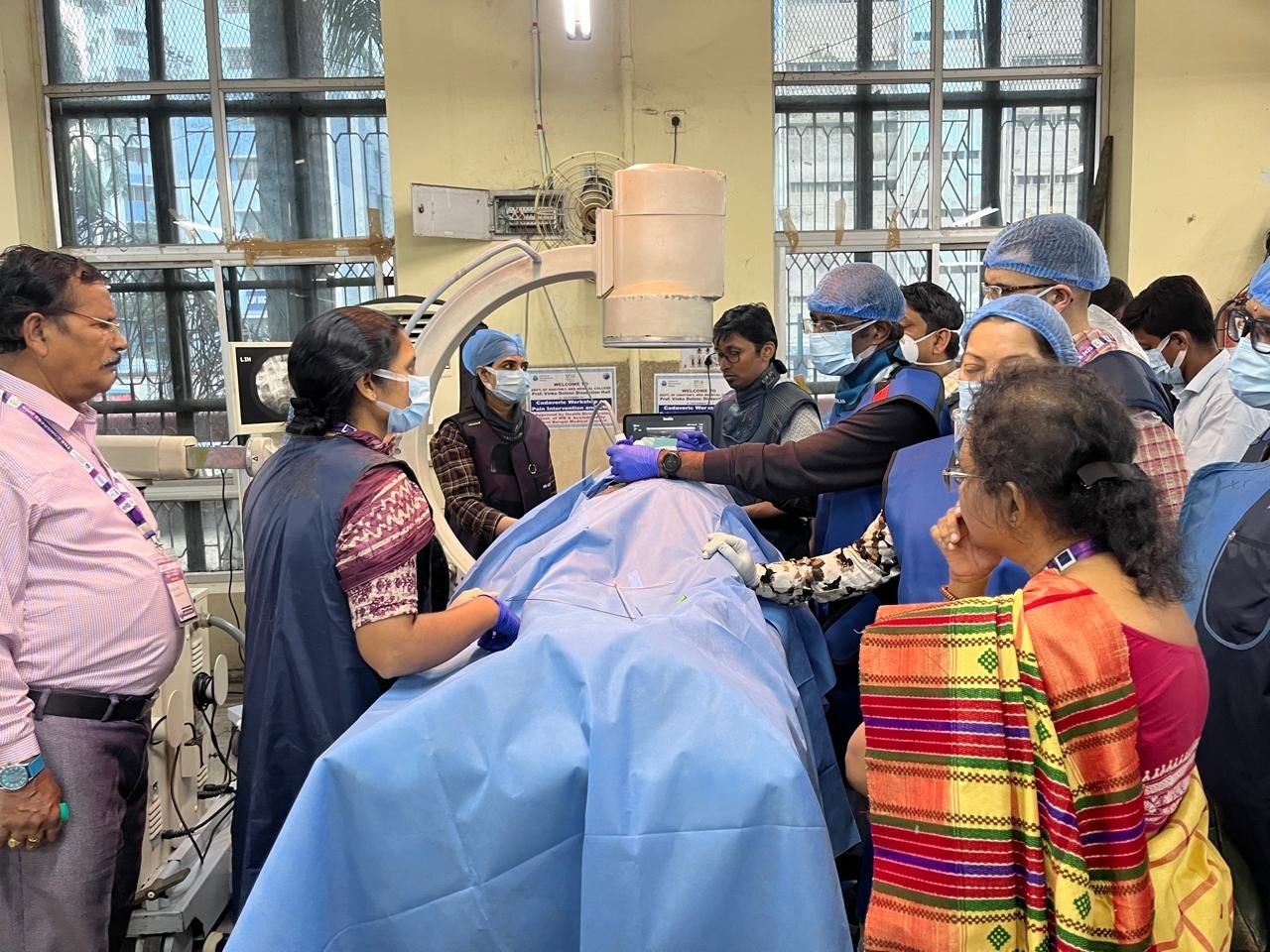 Hands-on clinical skills workshop in progress with participants in scrubs and caps
