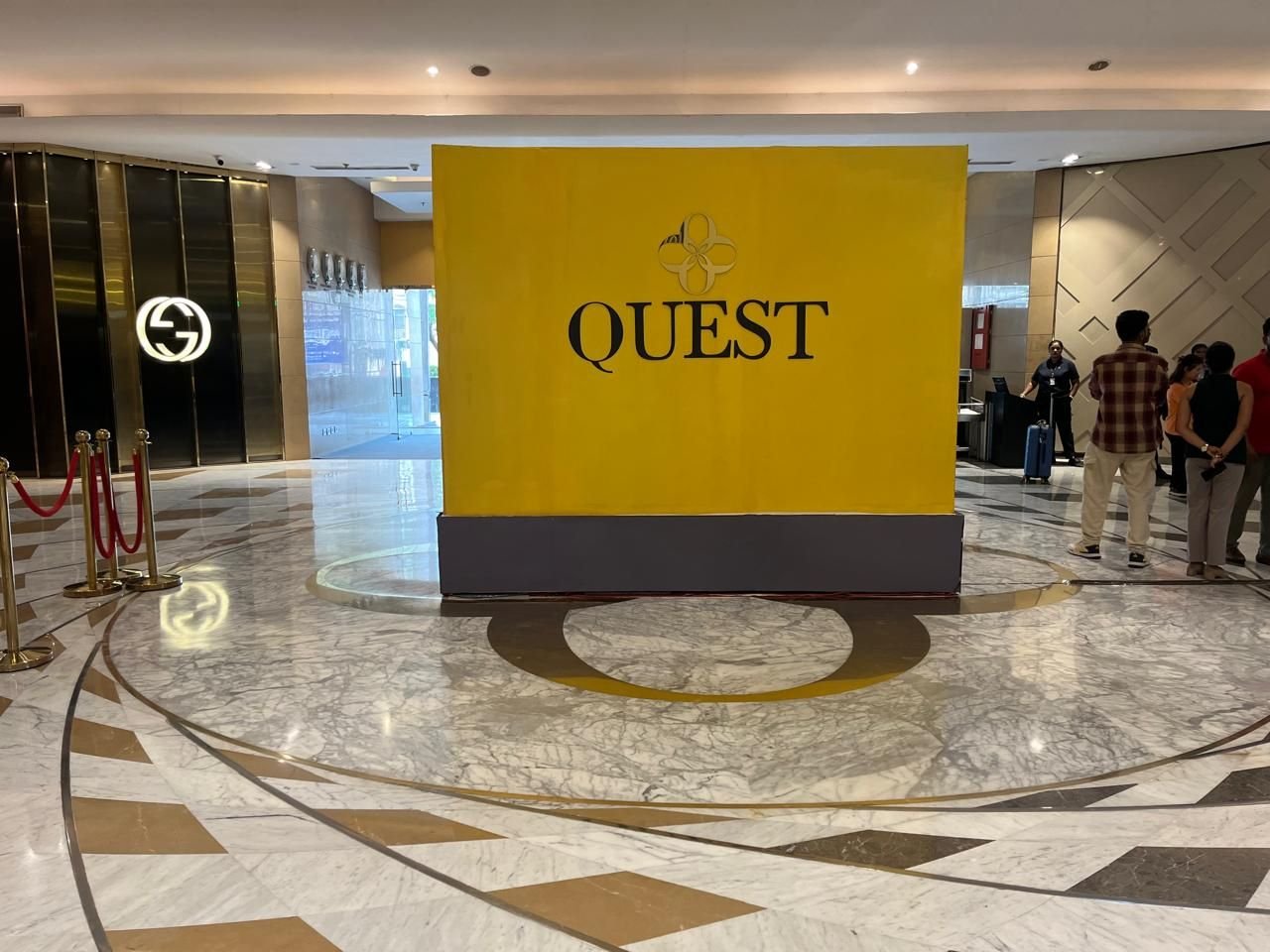 Gold brand cube installation standing in a polished luxury mall atrium