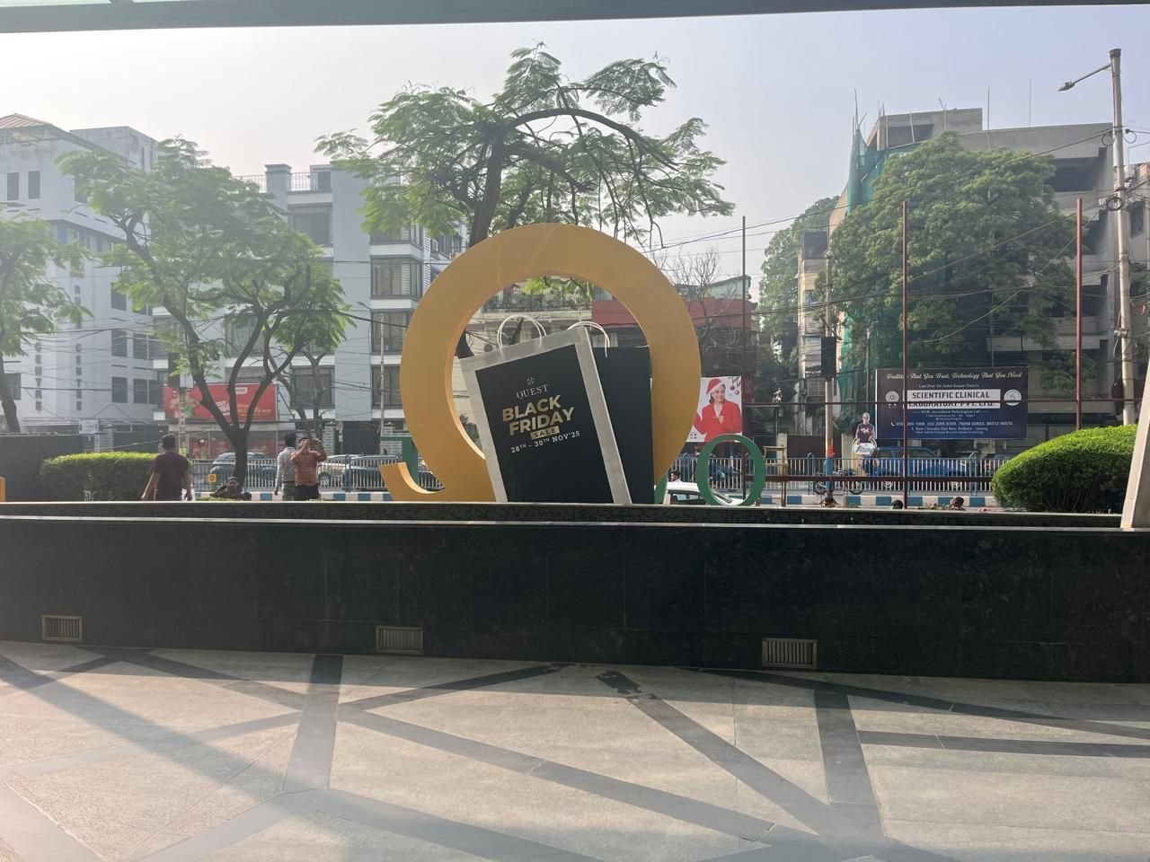 Large gold ring campaign installation in a mall forecourt seen from the street