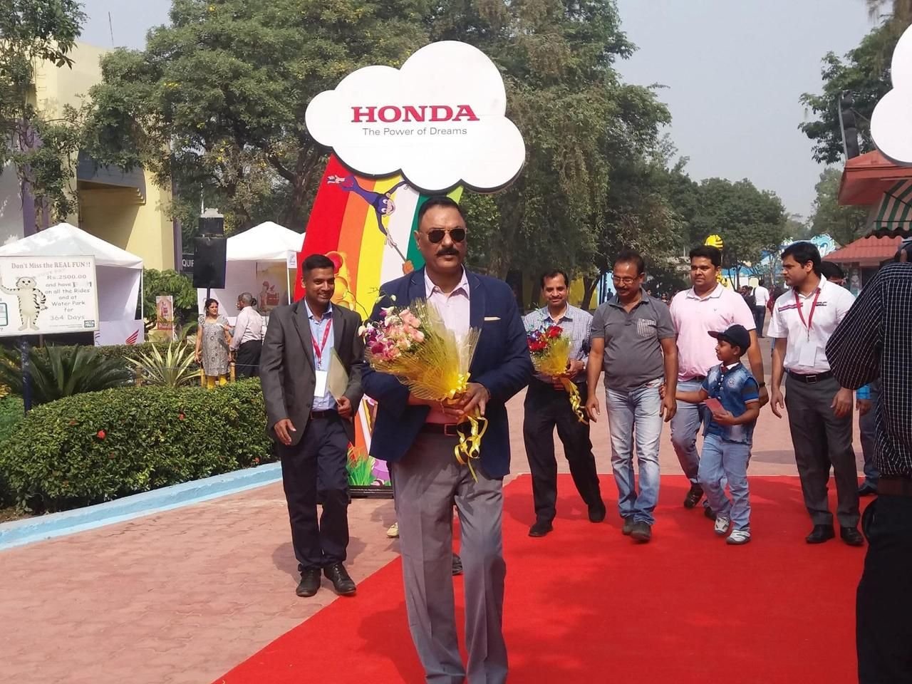 Guests arriving along a red-carpet welcome path lined with branded cloud-shaped signage
