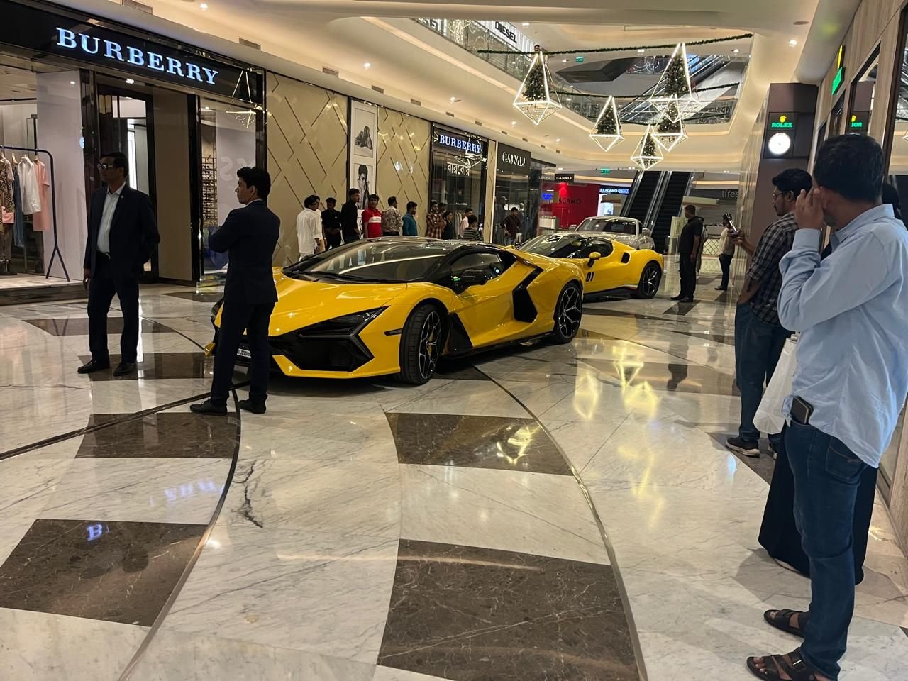 Supercars displayed in a mall atrium for a luxury automotive showcase